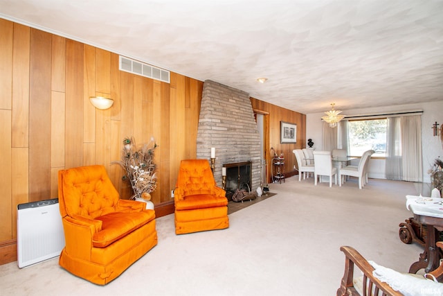 living area with carpet floors, visible vents, a fireplace, and wooden walls