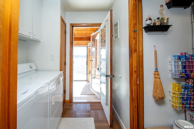 washroom with baseboards, cabinet space, and washing machine and clothes dryer