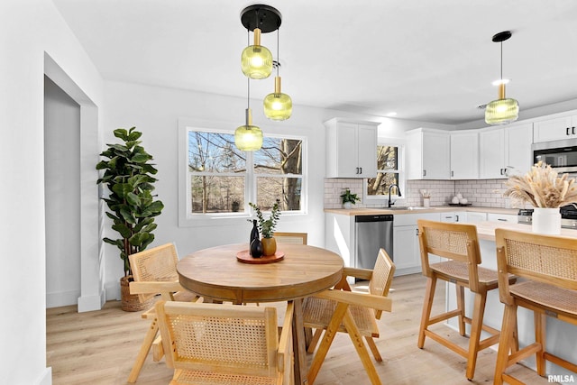 dining area featuring light wood-style floors and baseboards