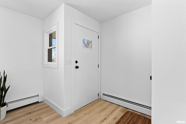 foyer entrance with light wood-style flooring and baseboard heating