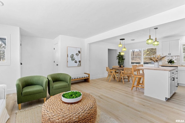 living area with light wood-style flooring and baseboards