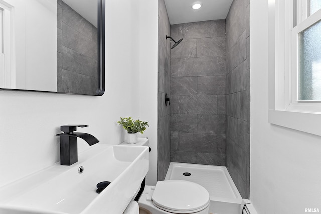 bathroom featuring a stall shower, a sink, and toilet