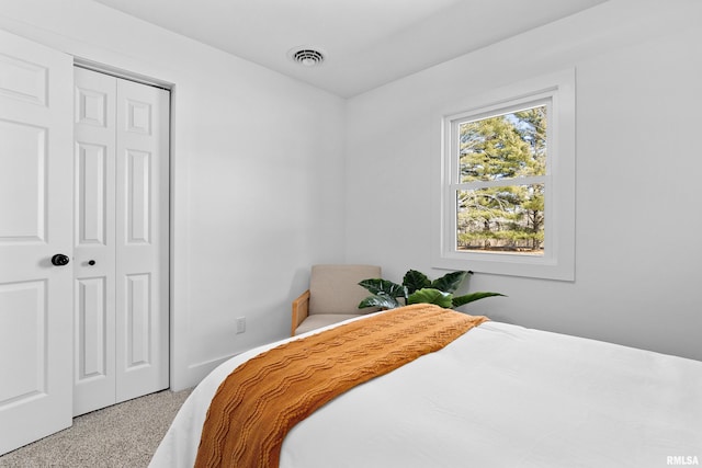 bedroom featuring carpet floors, visible vents, and a closet