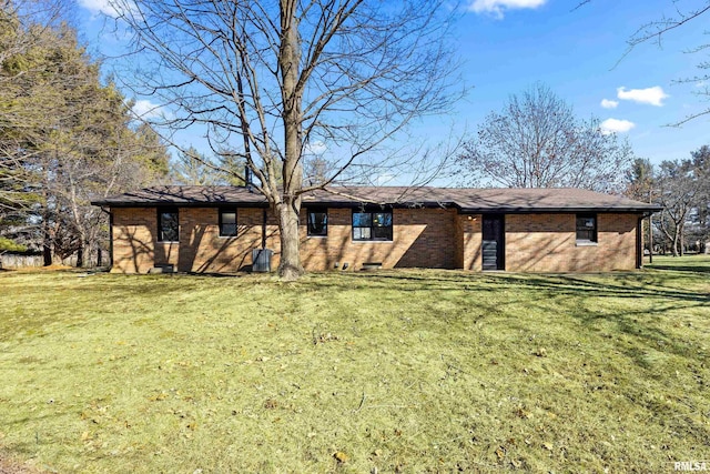 view of front facade with crawl space, brick siding, and a front yard