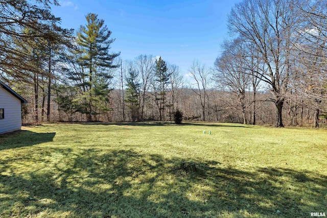 view of yard with a view of trees