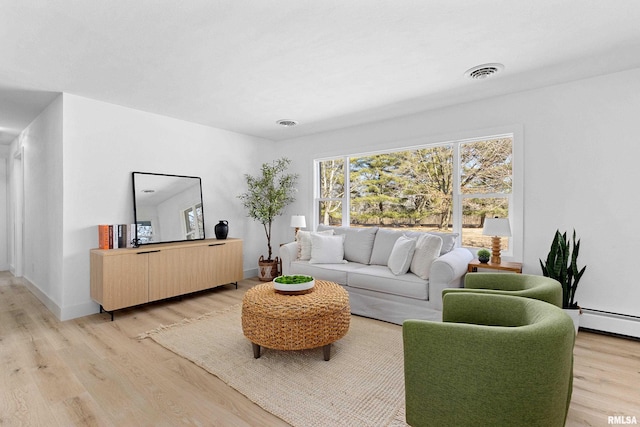 living room featuring a baseboard radiator, light wood-type flooring, visible vents, and baseboards