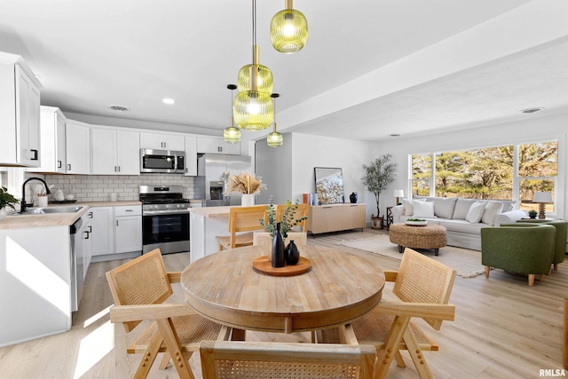 dining room with light wood-style flooring and recessed lighting