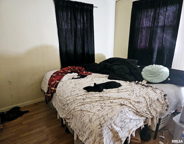 bedroom featuring wood finished floors and baseboards