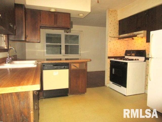 kitchen with white appliances, tasteful backsplash, ventilation hood, light floors, and a sink