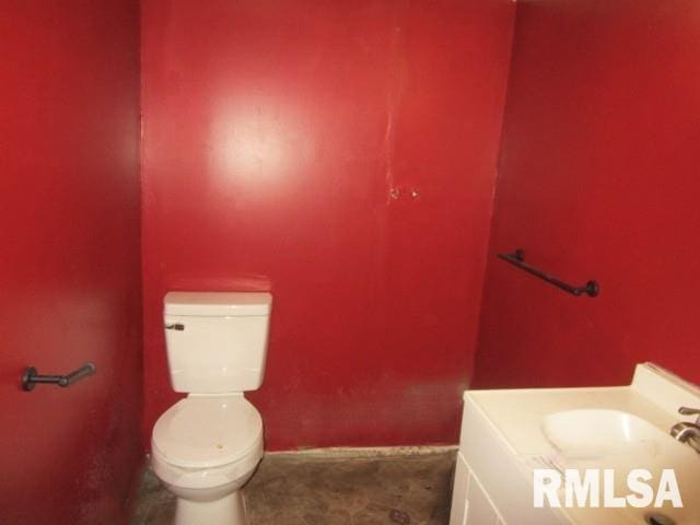 bathroom featuring toilet, baseboards, and a sink