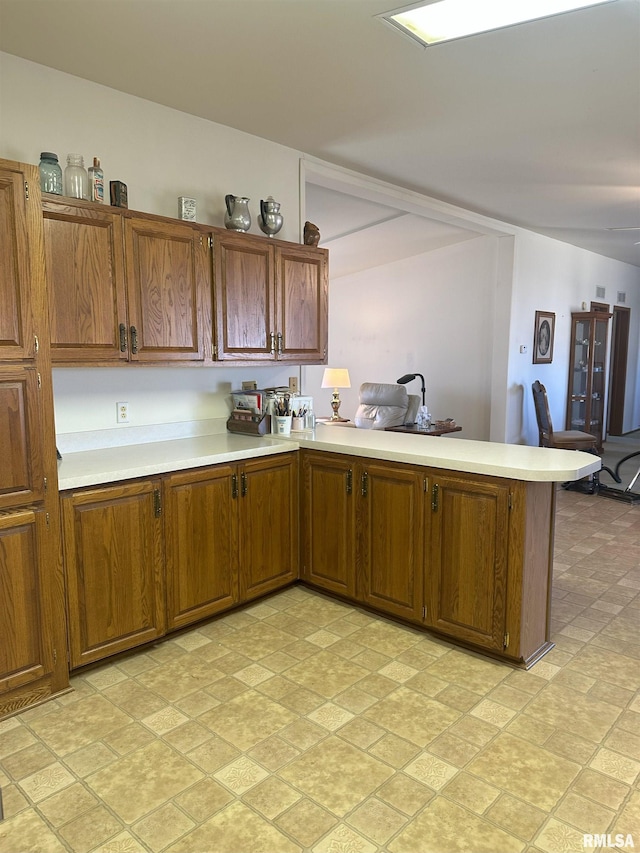 kitchen with brown cabinets, light countertops, and a peninsula