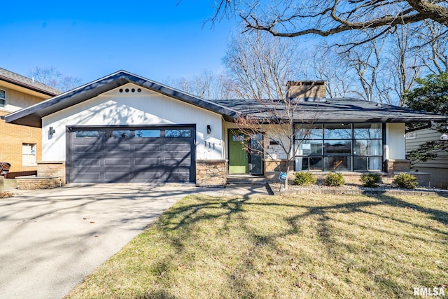 view of front facade featuring a front yard, driveway, a chimney, stone siding, and a garage