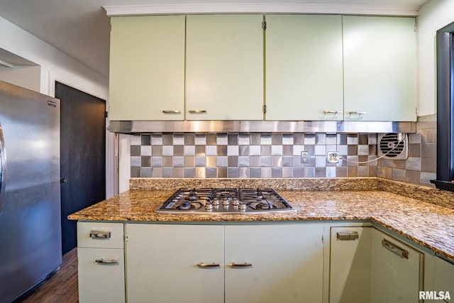 kitchen with light stone counters, decorative backsplash, stainless steel appliances, and dark wood-type flooring