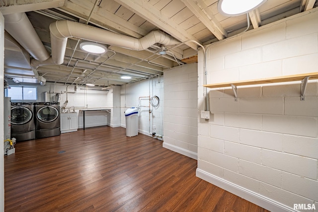 laundry room featuring concrete block wall, dark wood finished floors, laundry area, separate washer and dryer, and gas water heater