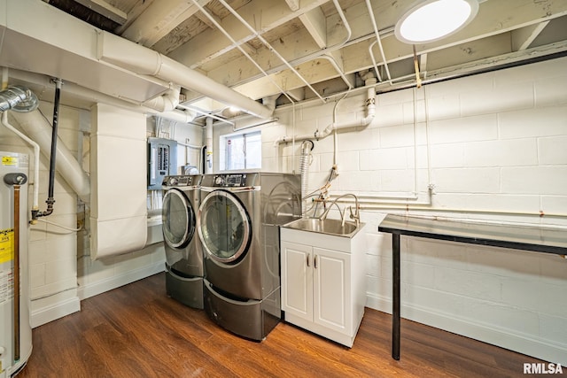 washroom featuring dark wood-type flooring, a sink, concrete block wall, laundry area, and washing machine and clothes dryer