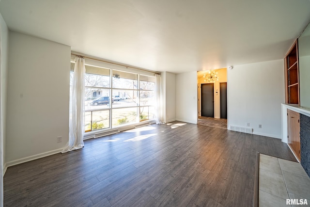 unfurnished living room with visible vents, baseboards, dark wood-type flooring, and floor to ceiling windows