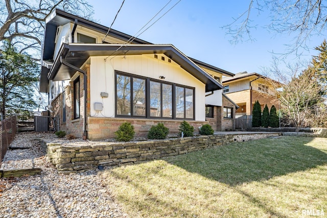 view of front of home featuring stone siding, a front yard, and fence