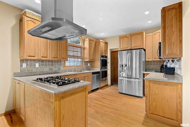 kitchen with a peninsula, light wood-type flooring, island range hood, and appliances with stainless steel finishes