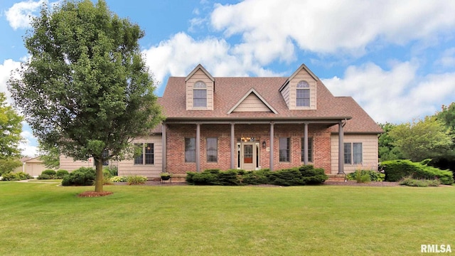 cape cod home with brick siding, a front yard, and a shingled roof