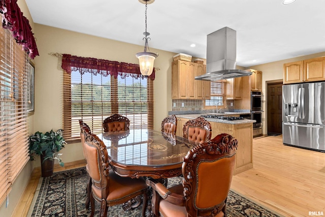 dining space featuring light wood-type flooring, baseboards, and recessed lighting