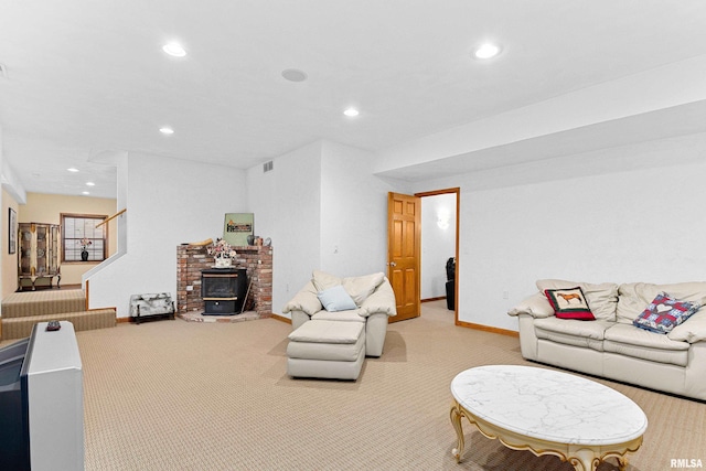 carpeted living room featuring stairs, baseboards, a wood stove, and recessed lighting