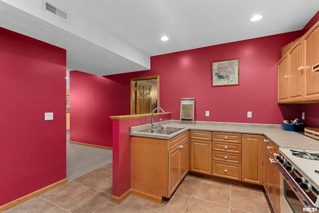 kitchen with range with two ovens, recessed lighting, a peninsula, a sink, and visible vents