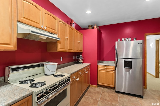 kitchen with under cabinet range hood, white gas range oven, stainless steel refrigerator with ice dispenser, and light countertops