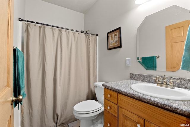 bathroom with curtained shower, vanity, and toilet