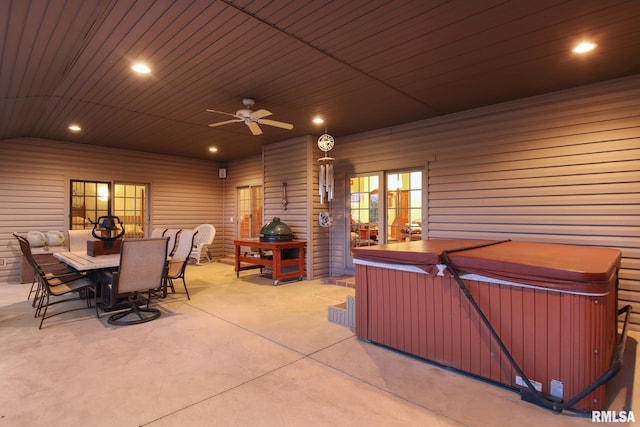 view of patio / terrace with a hot tub, outdoor dining area, and a ceiling fan