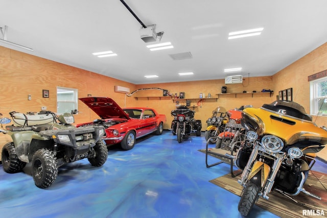 garage with a wall unit AC and a garage door opener