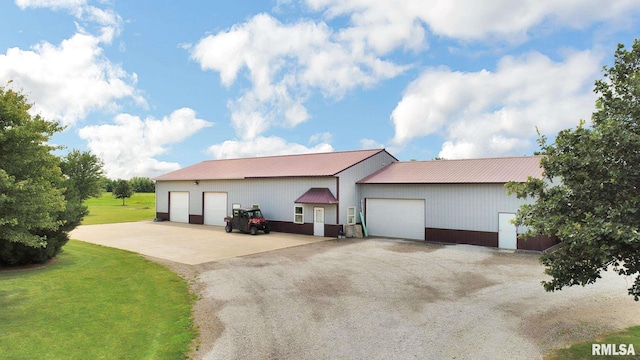 view of front facade featuring metal roof, a detached garage, and a front lawn