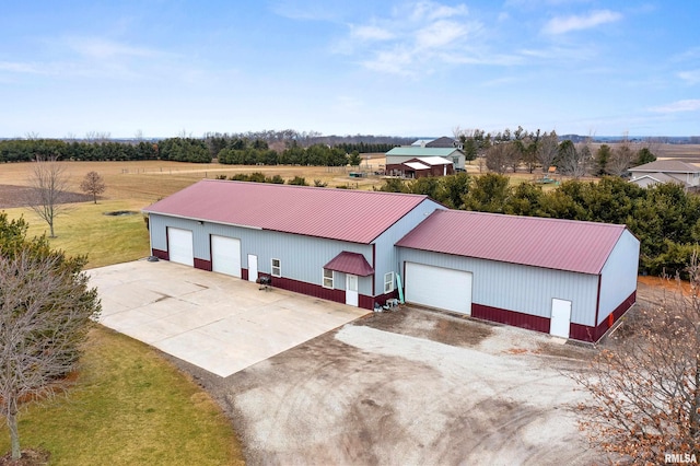 view of front of home with metal roof, an outdoor structure, and driveway