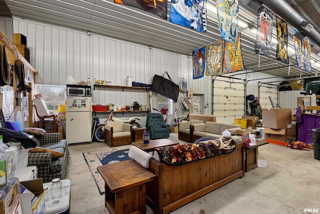 garage featuring metal wall and freestanding refrigerator