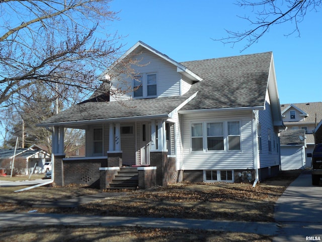 bungalow with a porch and roof with shingles