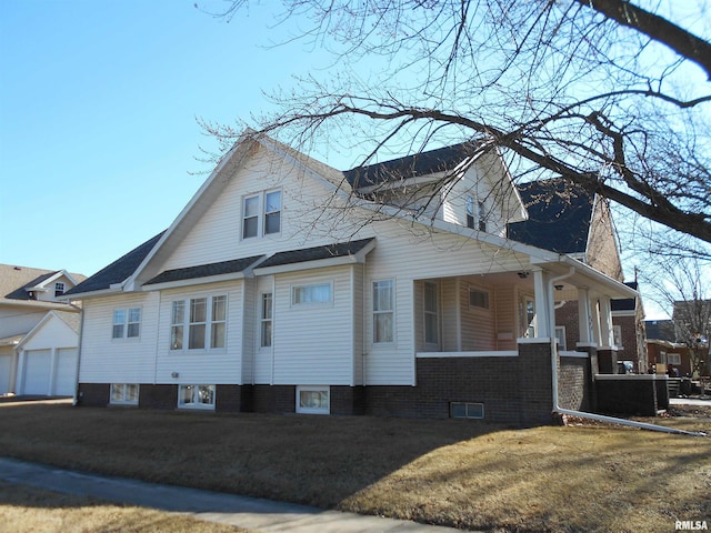 view of property exterior featuring a garage, a porch, and a lawn