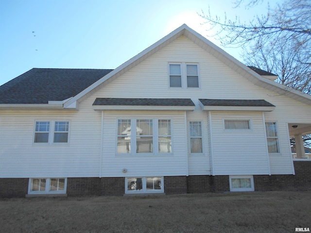 rear view of property with a shingled roof