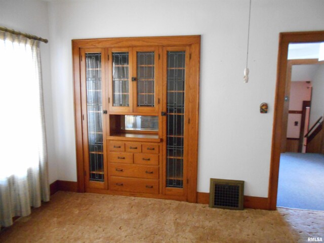 interior space with light carpet, baseboards, and visible vents