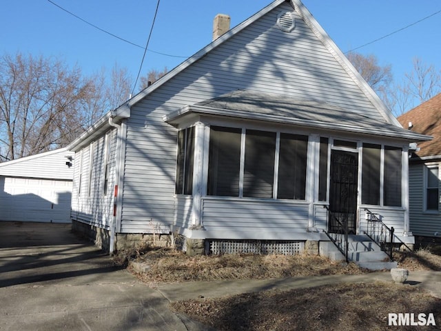 exterior space with an outbuilding, a sunroom, and entry steps