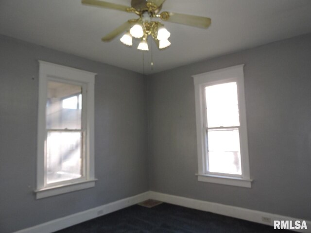 empty room with ceiling fan, dark wood-style flooring, and baseboards