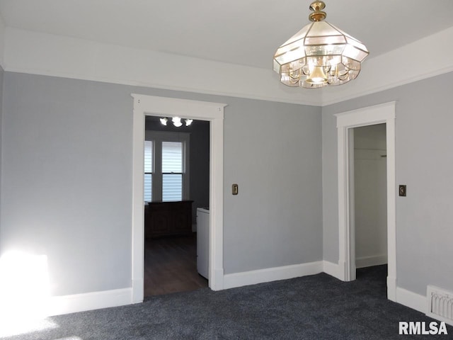 spare room with an inviting chandelier, baseboards, visible vents, and dark colored carpet