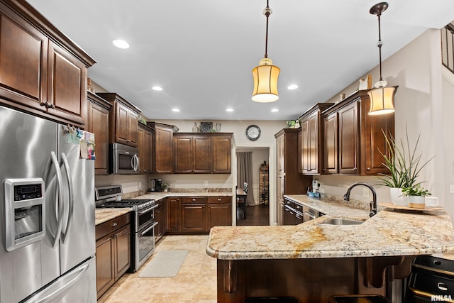 kitchen featuring recessed lighting, appliances with stainless steel finishes, a sink, dark brown cabinetry, and a peninsula