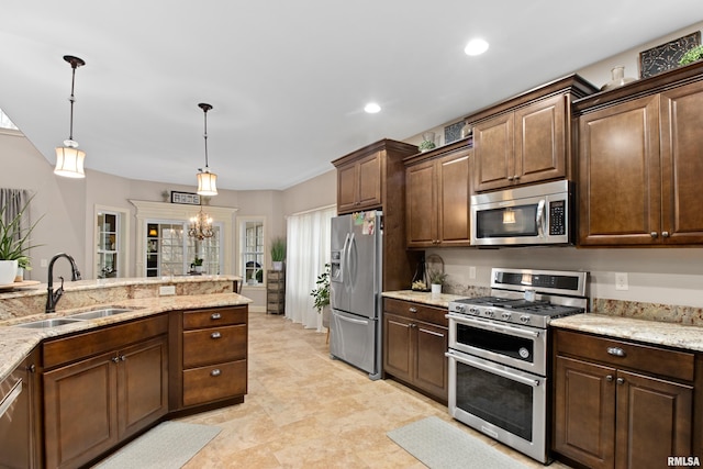 kitchen featuring decorative light fixtures, stainless steel appliances, an inviting chandelier, a sink, and light stone countertops