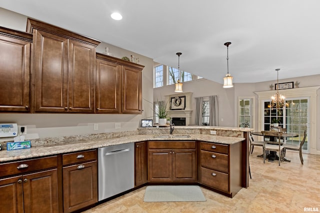 kitchen featuring decorative light fixtures, a sink, a peninsula, and stainless steel dishwasher