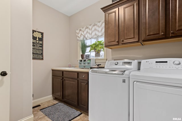 clothes washing area with cabinet space, visible vents, baseboards, washing machine and clothes dryer, and a sink