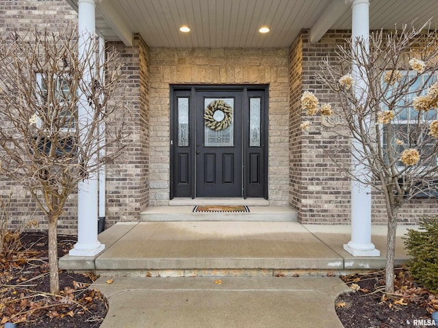 view of exterior entry featuring brick siding