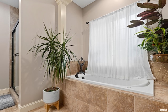 bathroom featuring tiled bath, decorative columns, baseboards, and an enclosed shower