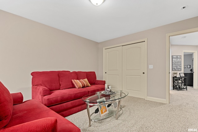 carpeted living area featuring baseboards