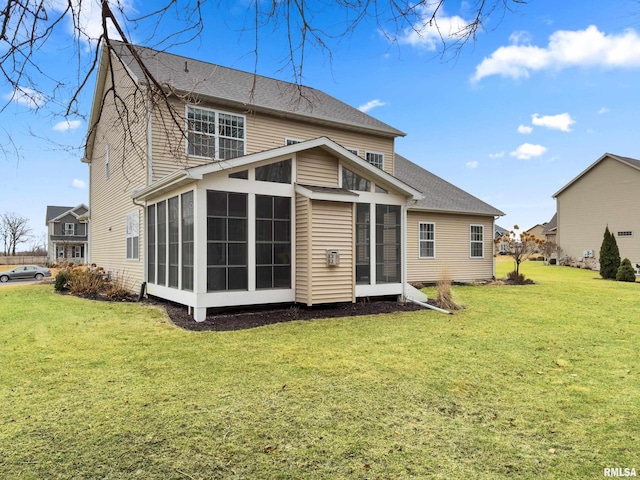 rear view of house with a lawn and a sunroom