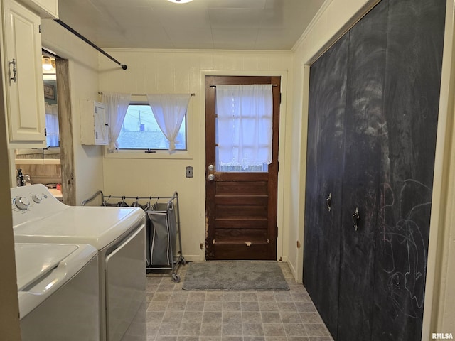 laundry area featuring cabinet space, ornamental molding, and washer and dryer