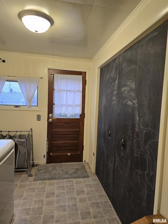 doorway with wood walls and ornamental molding